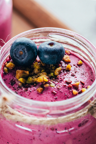 close-up view of sweet healthy smoothie with granola| nuts and blueberries
