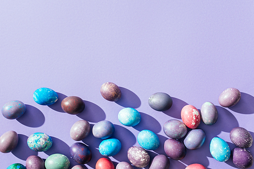top view of traditional colorful easter eggs| on purple with copy space