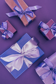 top view of decorative gift boxes with ribbons and bows on purple