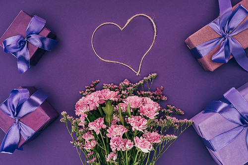 bouquet of beautiful pink flowers| heart-shaped rope and gift boxes on violet