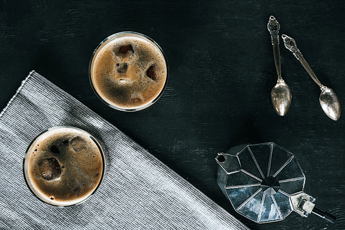 flat lay with coffee maker| glasses of cold iced coffee and spoons on black tabletop