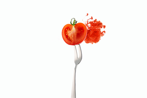 half of tomato on fork and red ink isolated on white