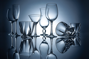 silhouettes of martini, cognac, champagne and wine empty glasses with reflections