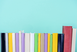 row of colored books isolated on blue