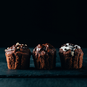 Sweet muffins with chocolate chips on dark background