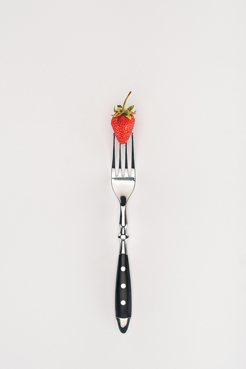 Raw strawberry on a fork isolated on white