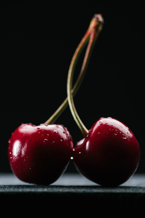 close-up view of fresh wet sweet cherries on black