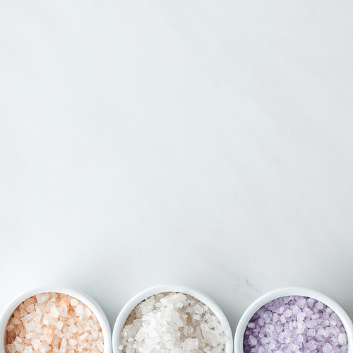 top view of colorful 씨솔트 in bowls on white background