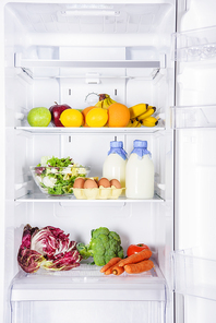 fruits, vegetables and milk with eggs in fridge