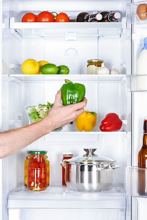 cropped image of man taking bell pepper from fridge