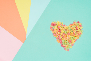 top view of jelly candies in shape of heart on colored surface