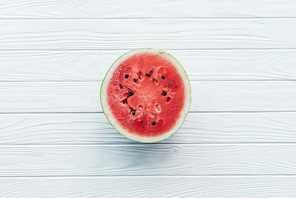 top view of fresh watermelon half on white wooden tabletop