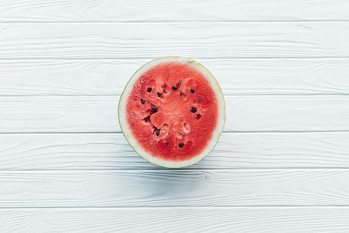 top view of fresh watermelon half on white wooden tabletop