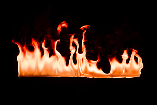 close up view of burning orange fire on black background