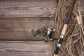 top view of fishing net and fishing rod on wooden planks