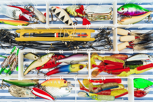 top view of fishing tackle and various bait in plastic box