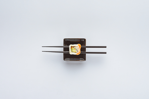 top view of tasty sushi and chopsticks isolated on white