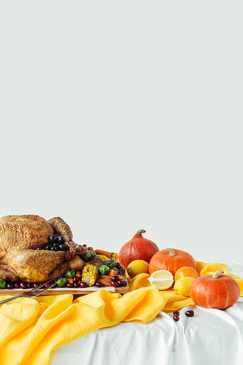 close up view of holiday dinner table set with roasted turkey and vegetables on grey background, thanksgiving holiday concept