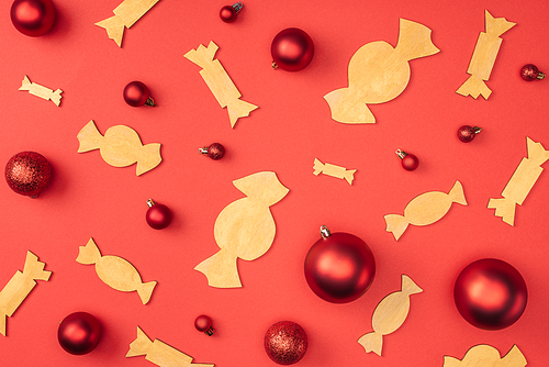 flat lay with red christmas toys and decorative wooden candies isolated on red
