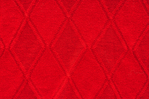 close up view of red woolen fabric with pattern as backdrop