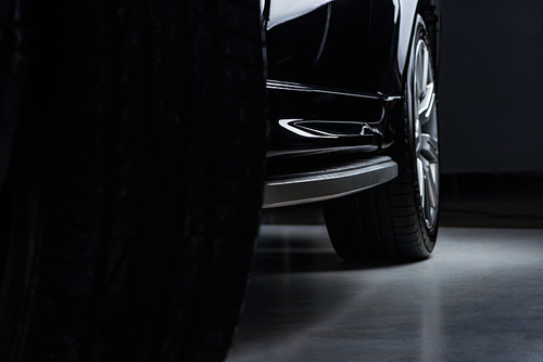 close up view luxury shining black automobile on dark background