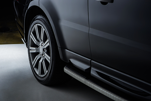 close up view luxury shining black automobile on dark background