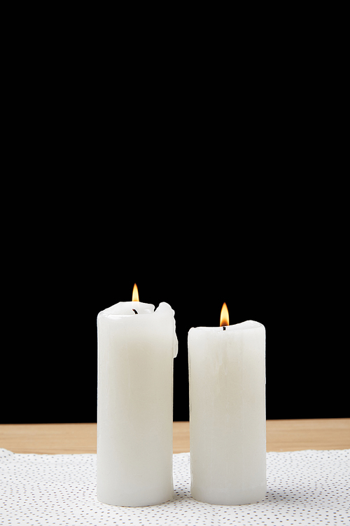Table with burning candles on black background