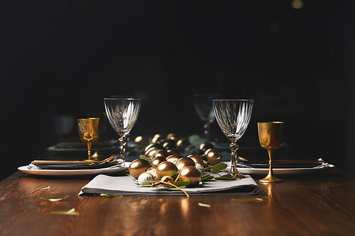 easter golden chicken eggs on wooden festive table in restaurant