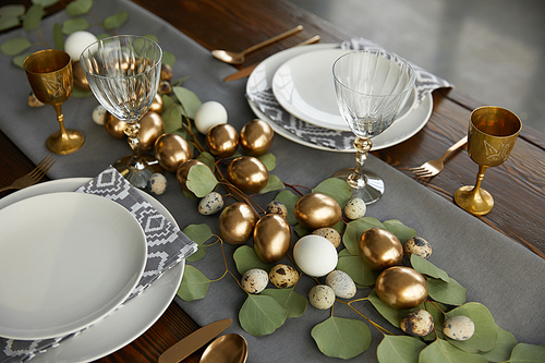 high angle view of golden chicken eggs and quail eggs on festive easter table
