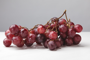 Close up view of pile of red grapes on gray