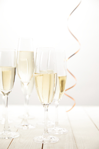 closeup view of champagne glasses with ribbon on white wooden table, holiday concept