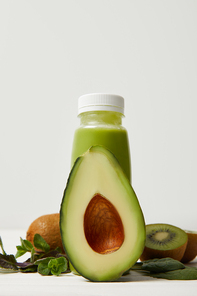 green smoothie with fresh avocado, kiwi and mint on wooden surface