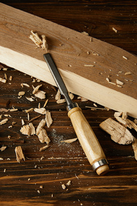 close up view of chisel and wooden pieces on brown table