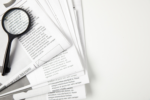 top view of magnifying glass and newspapers on grey, information concept