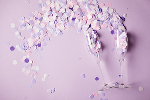 top view of confetti pieces and empty glasses on surface
