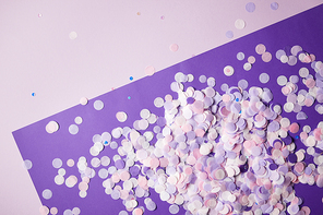 top view of confetti pieces on violet and dark violet surface