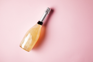 elevated view of bottle of champagne on pink surface