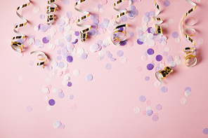 top view of violet confetti pieces on pink surface