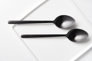 top view of two spoons and plate on white table, minimalistic concept