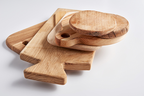 selective focus of stack of different wooden cutting boards on white table