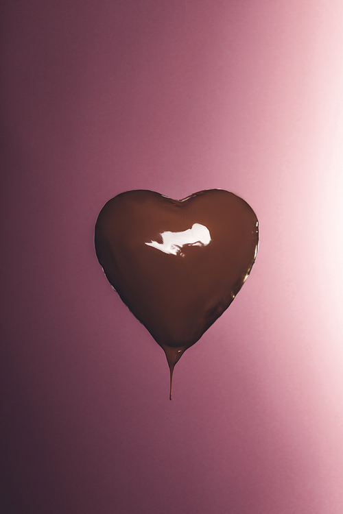 heart shaped candy with liquid chocolate isolated on pink