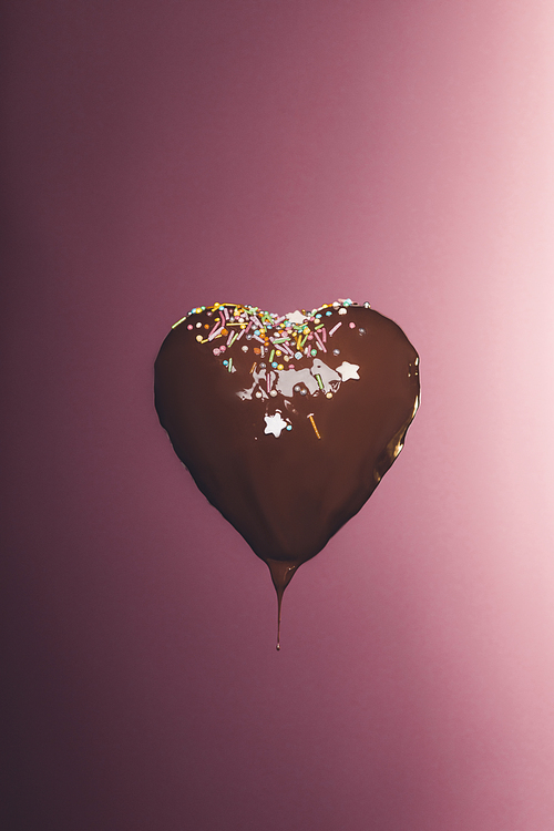 chocolate heart shaped candy with glaze isolated on pink
