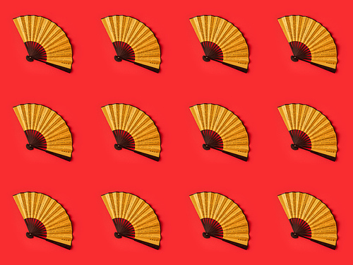 top view of decorative oriental fans pattern isolated on red