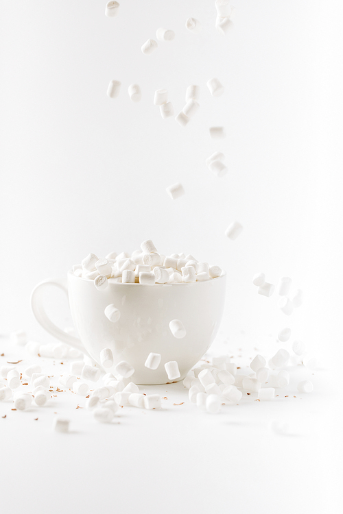 aromatic hot chocolate with falling marshmallows, isolated on white