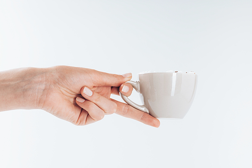 cropped view of hand holding cup of hot coffee, on white