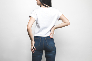 back view of attractive young woman in blank t-shirt on white