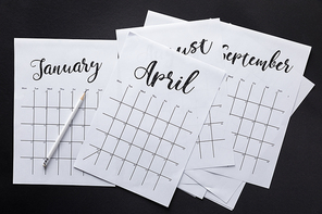 flat lay with paper calendar and pencil isolated on black