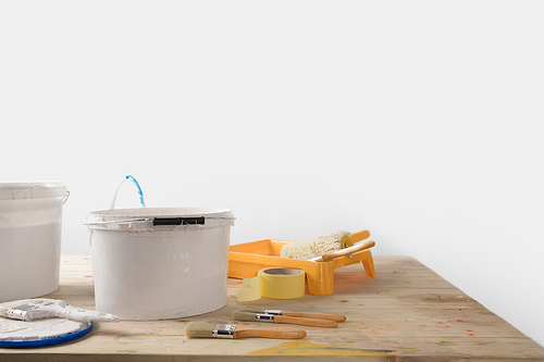 buckets with paints and plastic tray on wooden table