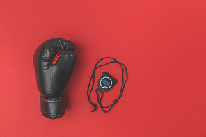 top view of boxing glove with stopwatch on red tabletop