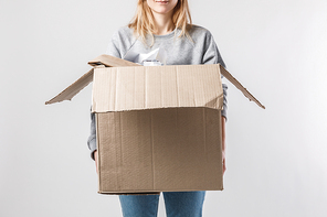 partial view of woman holding cardboard box with garbage in hands, recycle concept
